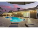 Inviting backyard pool with a covered patio, perfect for outdoor relaxation and entertaining under the evening sky at 2422 W Acoma Dr, Phoenix, AZ 85023