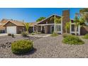 Welcoming home featuring desert landscaping, a chimney, and a two-car garage under a clear blue sky at 2422 W Acoma Dr, Phoenix, AZ 85023
