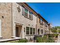 Attractive townhome exteriors with lush green landscaping and colorful shutters on a sunny day at 2631 S Sulley Dr # 104, Gilbert, AZ 85295