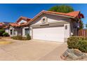 Charming single-Gathering home featuring a well-manicured lawn, a two-car garage, and a beautiful orange tile roof at 3109 N Meadow Dr, Avondale, AZ 85392