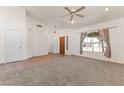 Bright living room featuring carpet flooring, a ceiling fan, and a large window with neighborhood views at 351 N Danyell Dr, Chandler, AZ 85225