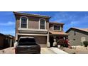 Two-story home featuring a charming tile roof, stucco siding, and a convenient two-car garage at 43822 W Baker Dr, Maricopa, AZ 85138