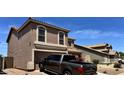 Front exterior of a two-story stucco home showcasing arched windows, a tile roof and two car garage at 43822 W Baker Dr, Maricopa, AZ 85138