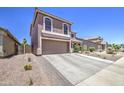 Lovely home showcasing desert landscaping, a driveway, and a two-car garage at 43822 W Baker Dr, Maricopa, AZ 85138