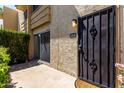 Close-up of front door of home with security gate and well maintained landscaping at 4630 N 68Th St # 264, Scottsdale, AZ 85251