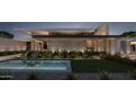 Modern home's architectural details are highlighted by its water feature and manicured landscaping at 6525 E Bluebird Ln, Paradise Valley, AZ 85253