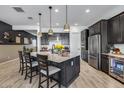Gourmet kitchen with stainless steel appliances, an oversized island with breakfast bar, and stylish pendant lighting at 7694 W Desert Spoon Dr, Peoria, AZ 85383