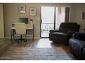 Bright room with work space, stylish furniture, and sliding glass doors to a balcony with comfortable patio seating at 9450 N 94Th Pl # 205, Scottsdale, AZ 85258