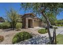 Charming home features a stone accent entry, a two-car garage, and well-maintained landscaping at 9752 E Torino Ave, Mesa, AZ 85212