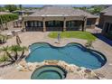 Aerial view of a private pool, spa, and outdoor kitchen in a luxurious backyard at 10033 W Jj Ranch Rd, Peoria, AZ 85383