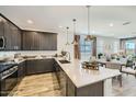 Open-concept kitchen with a spacious island, dark cabinetry, and a seamless flow to the dining and living area at 1415 W J Waltz Way, Apache Junction, AZ 85120