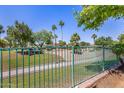 View of community park from the property, with walking paths, green grass and mature trees at 14819 W Lupine Ln, Surprise, AZ 85374