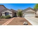 Charming single-story home with well-maintained landscaping and a two-car garage at 14819 W Lupine Ln, Surprise, AZ 85374