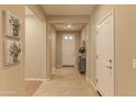 Inviting hallway with neutral tones, tiled flooring, and a view of the front door, enhancing the home's warmth at 16417 W Piccadilly Rd, Goodyear, AZ 85395