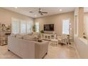 Cozy living room featuring plantation shutters, tile floors, and comfortable seating, ideal for relaxation at 16417 W Piccadilly Rd, Goodyear, AZ 85395