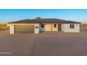 Charming single-story home featuring a gray garage door and a well-maintained desert landscape at 16627 N Slate Ln, Maricopa, AZ 85139