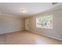Open living room features tile flooring, neutral paint, and natural light from the window at 1811 W Roma Ave, Phoenix, AZ 85015