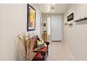 Bright hallway with tile flooring, neutral walls, accent furniture and an artful display at 1819 W Deer Creek Rd, Phoenix, AZ 85045