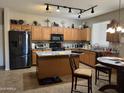 Functional kitchen with granite countertops, wood cabinets, a kitchen island, and stainless steel appliances at 20931 E Desert Hills Blvd, Queen Creek, AZ 85142