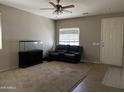 Cozy living room featuring neutral carpet and a ceiling fan, offering a relaxing space at 20931 E Desert Hills Blvd, Queen Creek, AZ 85142