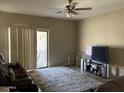 Bright living room with sliding glass doors to backyard patio, a ceiling fan, and neutral carpet at 20931 E Desert Hills Blvd, Queen Creek, AZ 85142