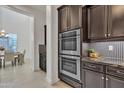 Modern kitchen with stainless steel appliances, dark wood cabinets, and stylish backsplash at 2219 E Galileo Dr, Gilbert, AZ 85298