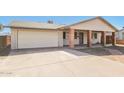 Inviting single-story home with attached garage, covered porch supported by brick pillars, and a paved driveway at 2227 N 57Th Dr, Phoenix, AZ 85035