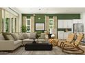 Bright, modern living room with stylish furniture, including a plush sectional sofa and woven chairs at 23146 E Lords Way, Queen Creek, AZ 85142