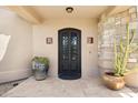 Elegant front door with a wrought iron design, stone accents, and potted succulents at 24200 N Alma School Rd # 7, Scottsdale, AZ 85255