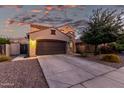 Charming single-Gathering home with a brown two car garage, extended drive and colorful desert landscaping at 2993 E Meadowview Dr, Gilbert, AZ 85298
