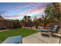 Serene backyard oasis with lush artificial grass, desert landscaping, and comfortable patio seating at 30259 N Sunray Dr, San Tan Valley, AZ 85143