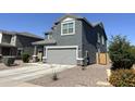 Stylish two-story home featuring a gray exterior, well-manicured landscaping, and a spacious driveway at 322 S Soledad Ct, Casa Grande, AZ 85194
