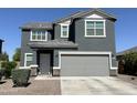 Attractive two-story home with a gray exterior, well-maintained yard, and attached garage at 322 S Soledad Ct, Casa Grande, AZ 85194