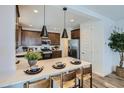 A well-appointed kitchen showcasing a breakfast bar, stainless steel appliances, and wood-look floors at 3332 S Lotus Ave, Mesa, AZ 85212