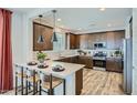 A well-appointed kitchen showcasing a breakfast bar, stainless steel appliances, and wood-look floors at 3332 S Lotus Ave, Mesa, AZ 85212