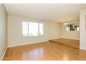 Bright and airy living room featuring wood floors, a large window, and an elevated seating area at 4062 W Eva St, Phoenix, AZ 85051