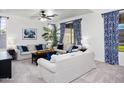 Bright living room featuring plush sofas, a ceiling fan, and patterned curtains at 4221 S Fireside Ct, Gilbert, AZ 85297