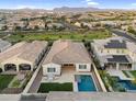 Aerial view of homes, green spaces, and community streets with mountain views in the distance at 4360 S Atom --, Mesa, AZ 85212
