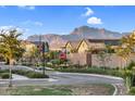 Neighborhood street view of well-maintained homes with desert landscaping and mountain views in the distance at 4360 S Atom --, Mesa, AZ 85212