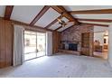 Inviting living room with exposed ceiling beams, a brick fireplace, and sliding glass doors to the backyard at 4515 N 35Th St, Phoenix, AZ 85018
