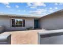 Home entryway featuring a blue door, brick tile, with a view of the front window at 4602 W Monte Cristo Ave, Glendale, AZ 85306