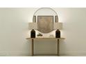 Elegant console table with lamps and decor, featuring a round mirror at 4808 S 232Nd Ln, Buckeye, AZ 85326
