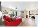 Bright living room with a red sofa, ceiling fan, sliding doors to a patio, and an entertainment area at 5335 E Shea Blvd # 1087, Scottsdale, AZ 85254