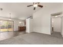 Open floor plan with neutral paint, carpet and tile flooring and sliding glass door to outside patio at 5401 W Jessica Ln, Laveen, AZ 85339