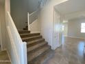 Bright foyer offers a staircase with white railing, neutral walls, and access to other rooms at 7216 E Blissful Breeze Ln, San Tan Valley, AZ 85143