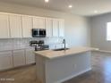 Modern kitchen with white cabinets, stainless steel appliances, a center island, and tile backsplash at 7216 E Blissful Breeze Ln, San Tan Valley, AZ 85143