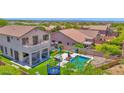 Beautiful backyard featuring a sparkling pool, lush turf, and comfortable seating at 7260 E Tasman St, Mesa, AZ 85207