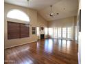 Spacious living room featuring gleaming hardwood floors, vaulted ceilings, and a cozy fireplace at 9285 E Sutton Dr, Scottsdale, AZ 85260