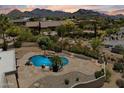 An aerial view showcases the backyard, pool, desert landscaping, and mountain views of this stunning desert home at 9349 E Calle De Valle Dr, Scottsdale, AZ 85255