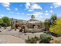 Stunning Santa Fe home showcasing desert landscaping, an elegant courtyard and a striking mountain backdrop at 9349 E Calle De Valle Dr, Scottsdale, AZ 85255